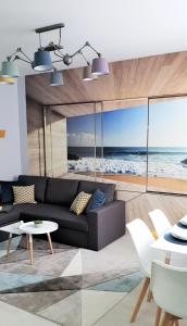 a living room with a couch and a view of the ocean at V-Apartments in Ostend