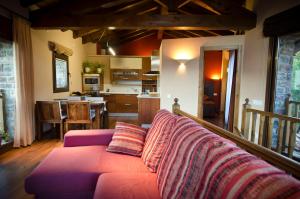 a living room with a purple couch and a kitchen at L'Estança de L'Era in La Pobleta de Bellvei