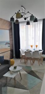 a living room with a couch and a table and chairs at V-Apartments in Ostend