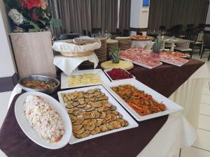 una mesa con muchos tipos diferentes de comida en ella en Hotel Senyor, en Rímini