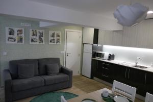 a living room with a couch and a kitchen at Belo Apartment in Leiria