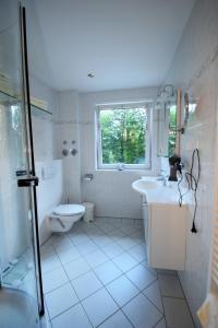 a bathroom with a sink and a toilet and a window at Cafe Steffens in Hahnenklee-Bockswiese