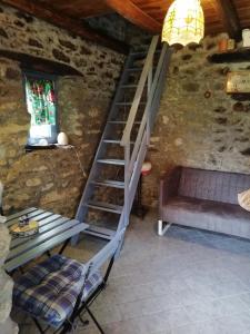 a staircase in a room with a table and a bench at Micro-Cottage in pietra La Ratatouille in Dego