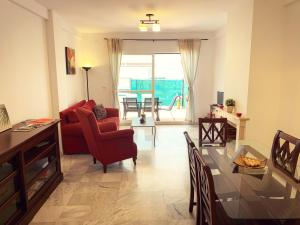 een woonkamer met een rode stoel en een glazen tafel bij Fantastic 3-Bedroom Holiday Home including Tennis and Pool Near Golf Course in El Portil