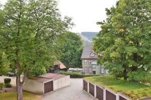 Blick auf ein Haus mit Bäumen und Bürgersteig in der Unterkunft Cafe Steffens in Hahnenklee-Bockswiese