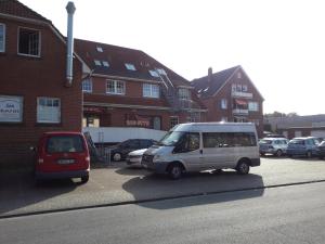 a van parked in a parking lot next to a building at Pension Norddeicher Straße in Norden +14 photos