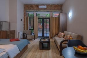 a living room with a bed and a couch at Wine Inn Borjomi Aparthotel in Borjomi