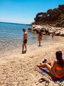 um grupo de pessoas numa praia perto da água em 200m de la plage ,3mn du port à 50m du centre ville em Carry-le-Rouet