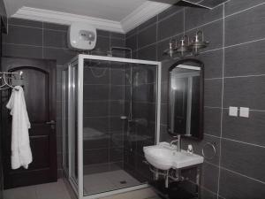 a bathroom with a sink and a shower and a mirror at Lady M guest House in Tema +38 photos