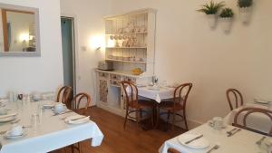 ein Esszimmer mit 2 Tischen und eine Küche in der Unterkunft Colebrook Guest House in Farnborough