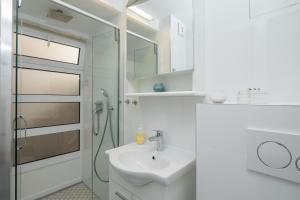 ein weißes Bad mit einem Waschbecken und einer Dusche in der Unterkunft Split Center Suites in Split