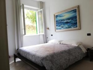 een slaapkamer met een bed en een raam bij Là Mì Cà in La Spezia