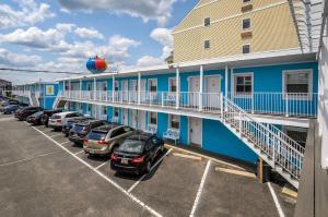 a row of cars parked in a parking lot in front of a building at Madison Beach Motel in Ocean City