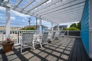 pérgola blanca en una terraza con sillas y mesas en Madison Beach Motel, en Ocean City