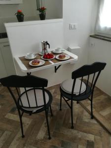 a small table with two chairs and plates of food on it at Holiday Homes - mini spa - Nemi (Roma) in Nemi