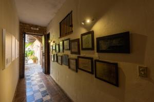 un pasillo con un montón de fotos en una pared en El Beaterio Casa Museo, en Santo Domingo
