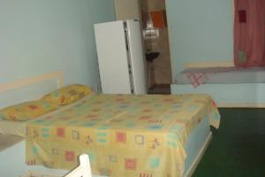 卡波布里奥Pousada Gran Gaviota的一间带床和冰箱的卧室