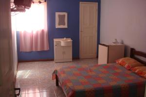 a bedroom with a bed and a window and a door at Pousada Gran Gaviota in Cabo Frio