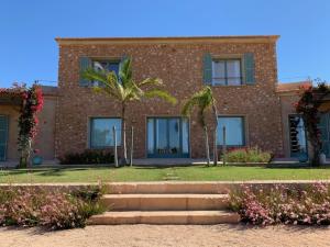 a brick building with a palm tree in front of it at Finca El Idilio in Ses Salines