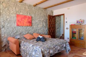 a bedroom with a bed and a stone wall at L'Atalaya D'or in Oropesa del Mar