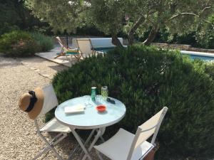 uma mesa branca e cadeiras num quintal em Villa Louanne em Pertuis