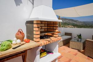 a outdoor kitchen with a pizza oven on a patio at L'Atalaya D'or in Oropesa del Mar