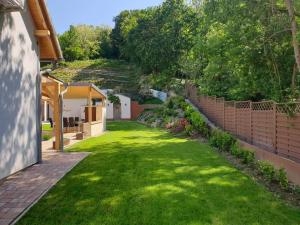 a yard with green grass and a brick fence at Villa Quality Wellness in Dozmat