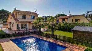 uma casa com uma piscina em frente a uma cerca em Luxury Villa near the Sea em Sant Antoni de Calonge