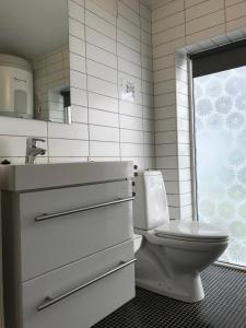 a bathroom with a toilet and a sink and a window at Bergen City Apartment Nygårdsgaten in Bergen