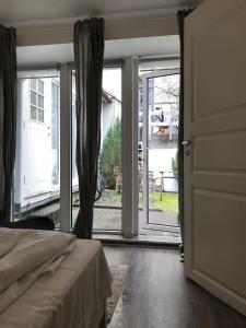 ベルゲンにあるBergen City Apartment Nygårdsgatenのベッドルーム1室(ベッド1台付)、スライド式ガラスドアが備わります。