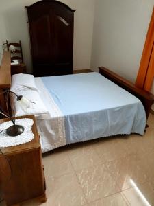 カルピニャーノ・サレンティーノにあるA dieci minuti dal mareのベッドルーム1室(ベッド1台、木製ドレッサー付)