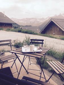 a picnic table with a plate of food and two benches at appartement au pied des pistes in La Chal