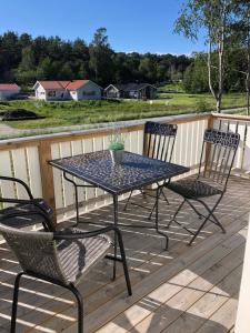 a patio table and two chairs on a deck at Medvik Högalid in Strömstad