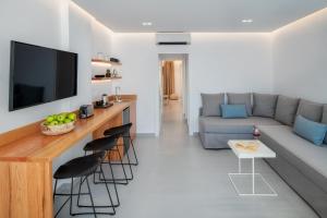 a living room with a couch and a bar with stools at Harmony Suites in Fira