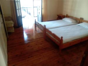 two beds in a room with a wooden floor at Georgina Apartments in Mesongi