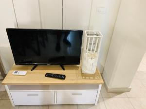 a flat screen tv sitting on a table with a remote control at Luxar room in Assemini