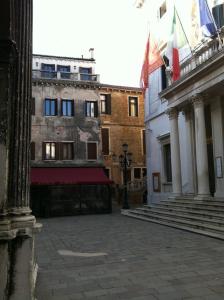 a building with flags flying in the middle of a street at Appartement Fenice II A in Venice