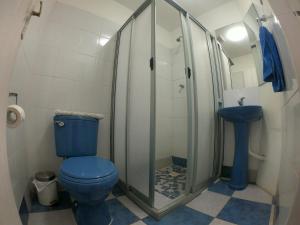 uma casa de banho com um WC azul e um lavatório. em Hostal Michel em Vicuña