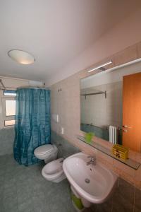 a bathroom with two toilets and a sink and a mirror at Residence Verbena in Rimini