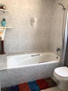 ein Badezimmer mit einer weißen Badewanne neben einem WC in der Unterkunft Casa Pepe in Regencós