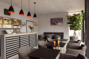 a bar with chairs and tables in a restaurant at Hôtel Le Nautic in Arcachon