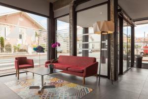 a living room with a red couch and a table at Hôtel Le Nautic in Arcachon