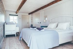 a white bedroom with two beds and a window at Farmors Lada in Glommen