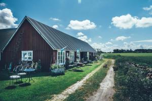 a barn with tables and chairs next to a field at Farmors Lada in Glommen