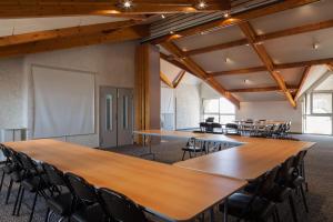 a conference room with tables and chairs and a white screen at Hôtel Le Nautic in Arcachon