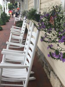 una fila de sillas blancas de césped alineadas contra una pared en Highlands Inn, en Highlands