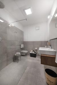 a bathroom with a sink and a tub and a toilet at Hotel Wilma in Nalles