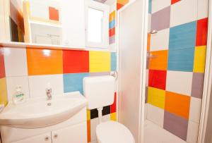 a colorful bathroom with a sink and a toilet at Apartment Zvone in Baška