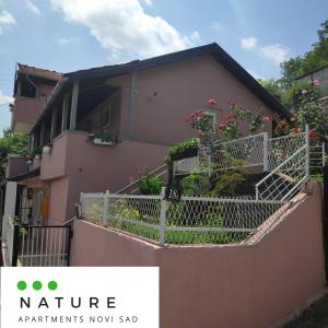 una casa con un balcón con flores. en Just nature en Novi Sad