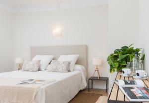 a bedroom with a white bed and a table at Boutique Hotel Oriola in Cala de Sant Vicenc